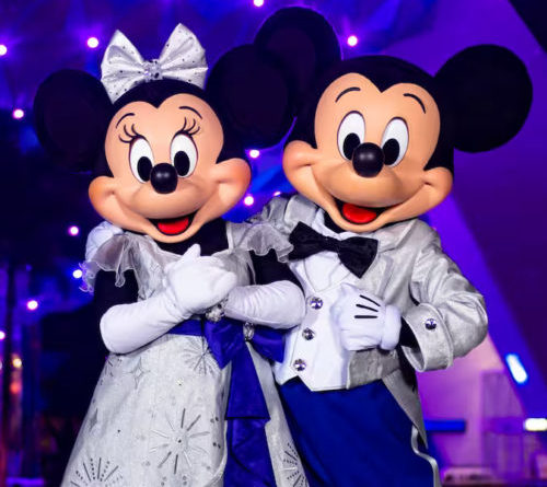Mickey and Minnie Mouse in front of Spaceship Earth in their Disney100 Costumes